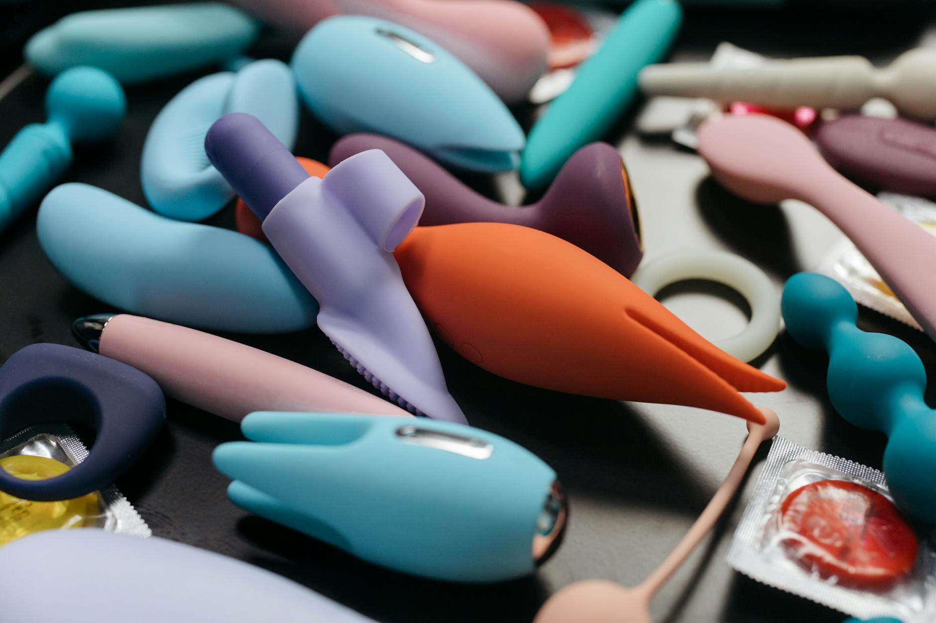 A woman holding a pink vibrator in her hand, surrounded by art books and soft textures, representing personal rediscovery.