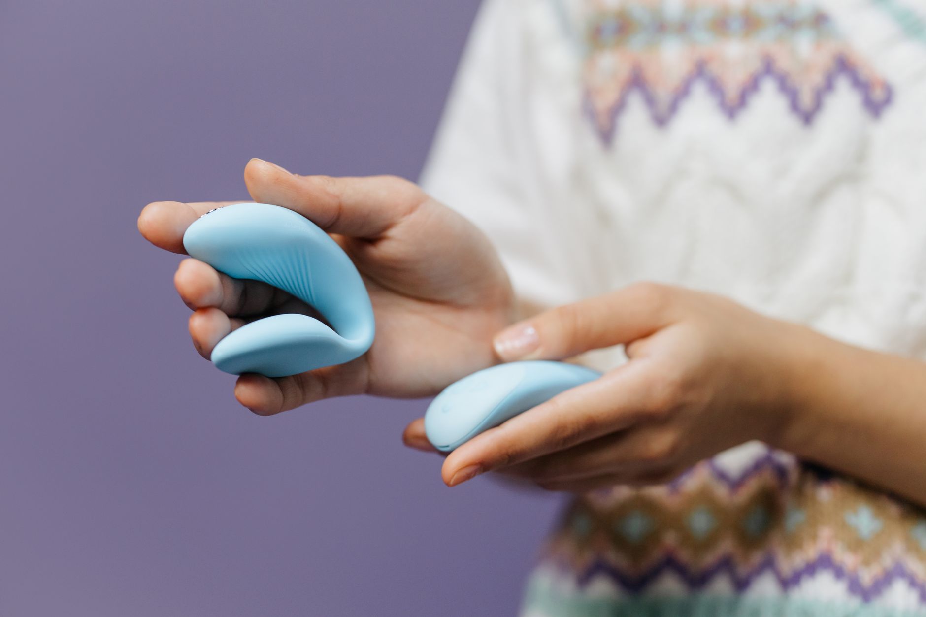 Hands holding a sleek lemon clitoral vibrator against a soft background, symbolizing intentional pleasure
