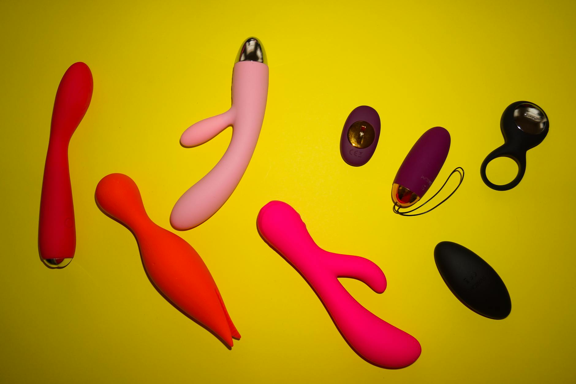 Close-up of hands holding a sleek vibrator against a purple background, representing personal intimacy and autonomy