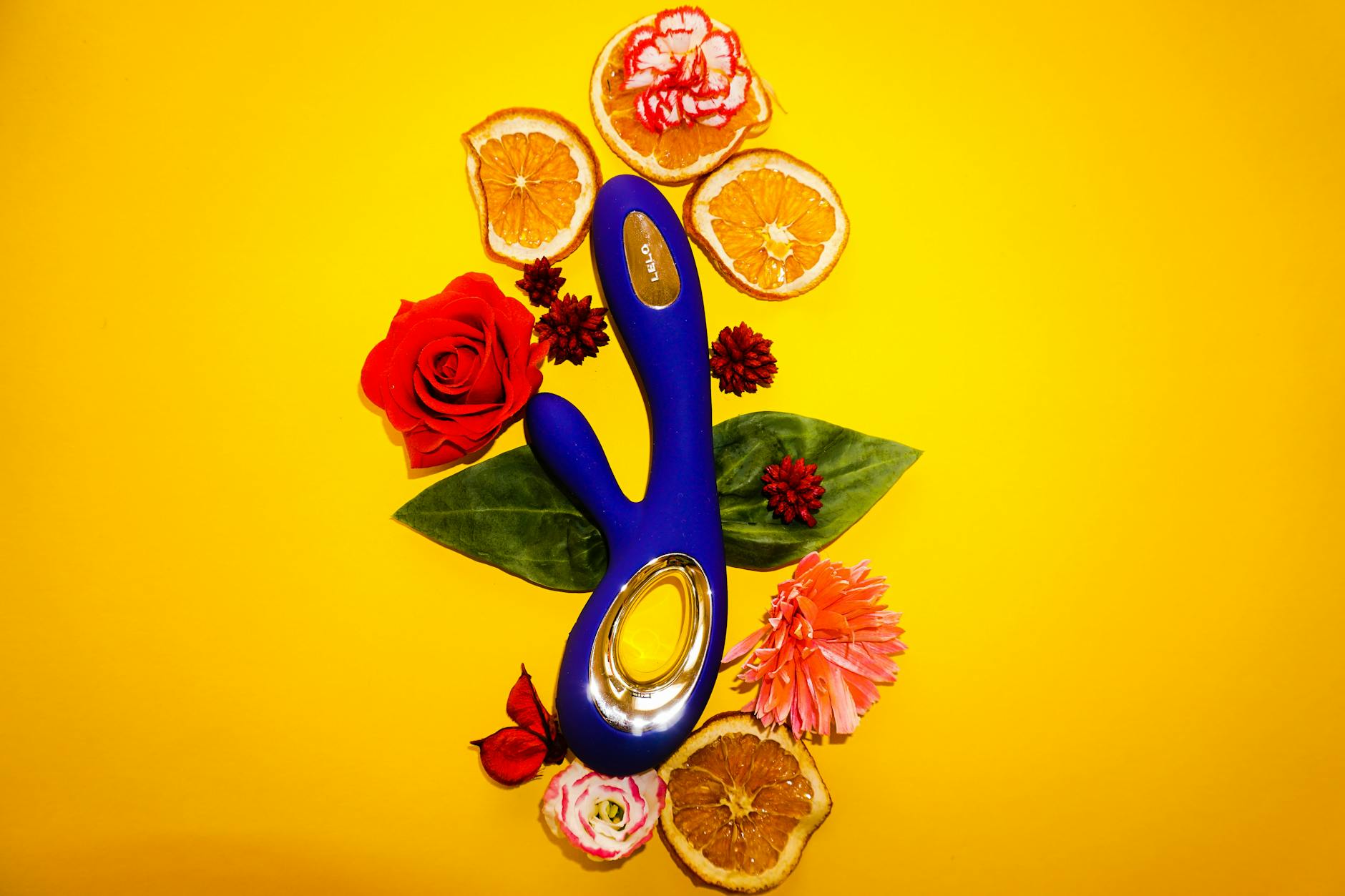 Close-up of hands holding a sleek blue lemon vibrator against a purple background