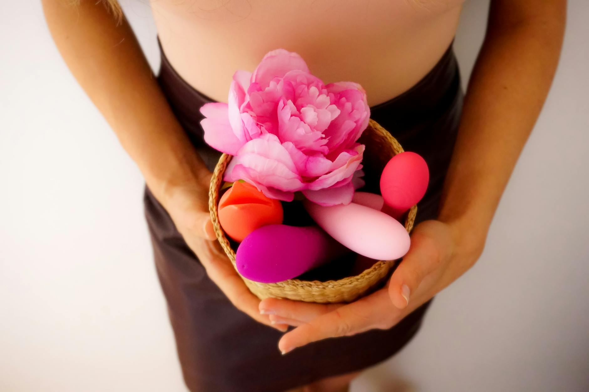 Colorful vibrators and flowers arranged on a bright yellow background